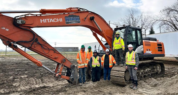 Team in front of excavator